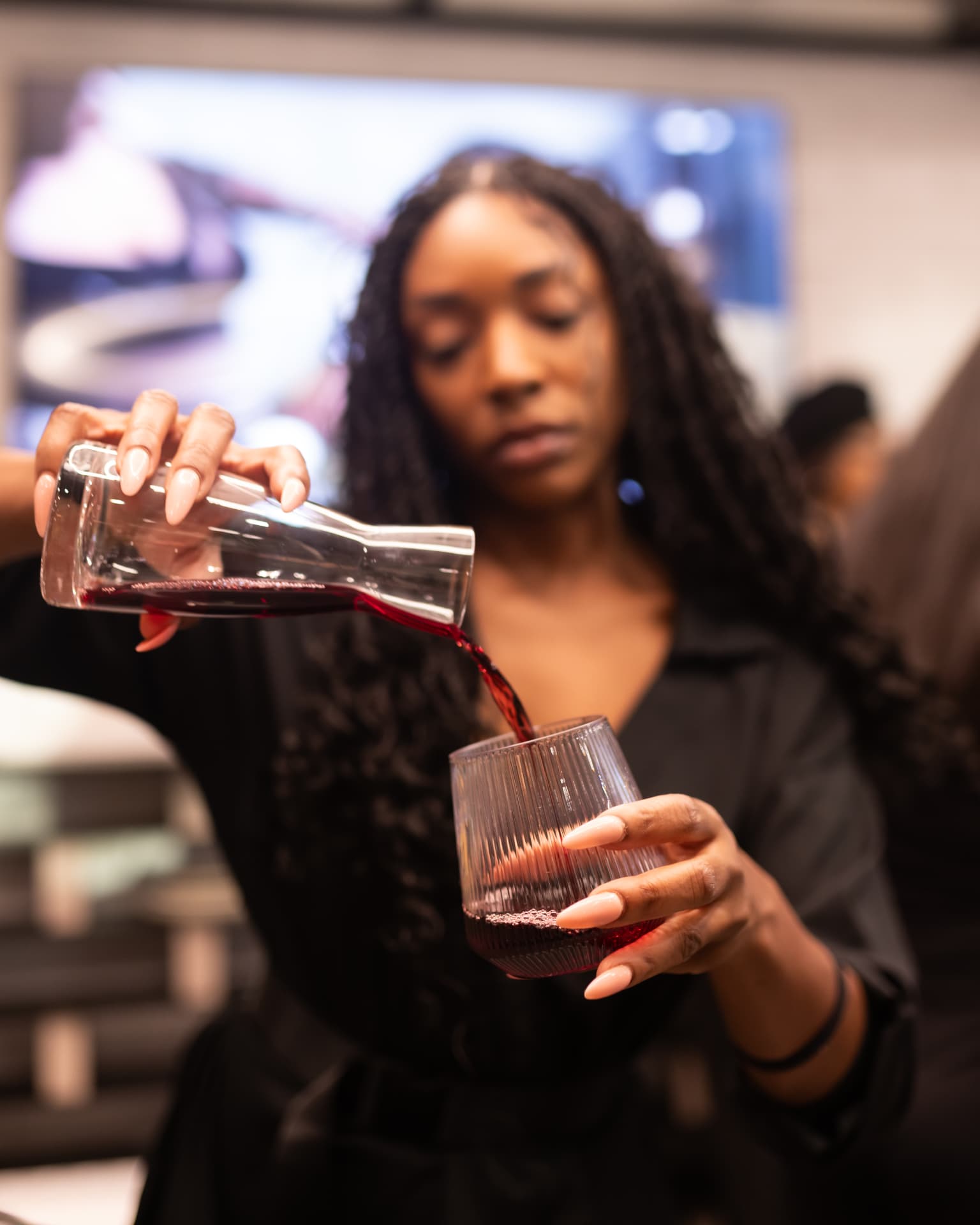 Guest pouring red wine from a decanter