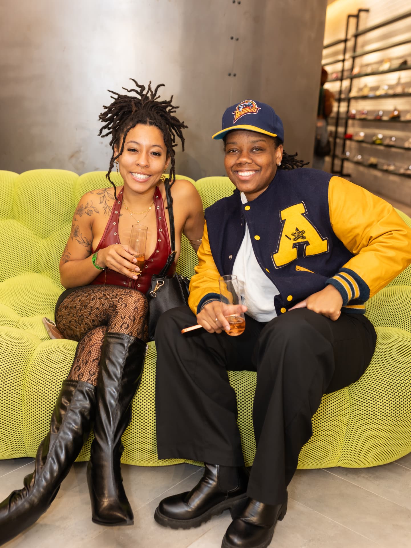 Two guests smiling on a chartreuse sofa at The Wine Down